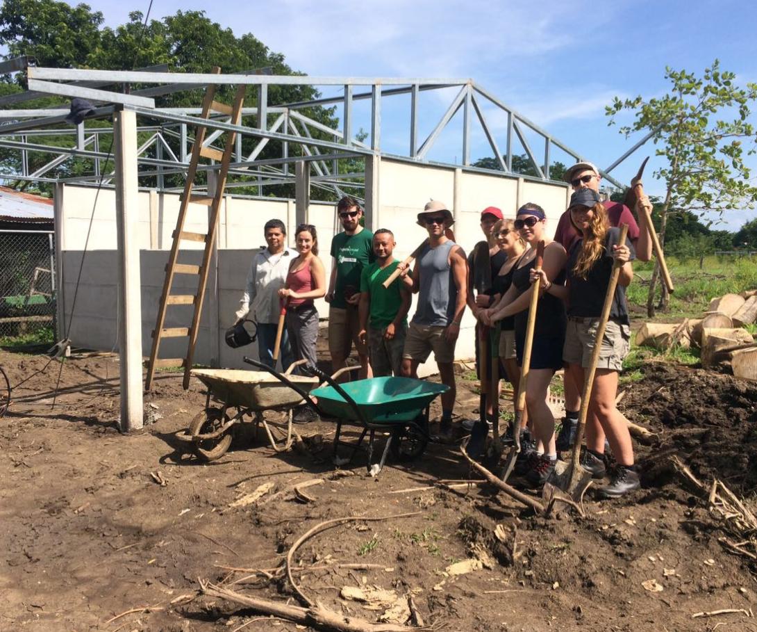 A group of corporate volunteers on a tailor-made trip take a break during building activities in Costa Rica. A corporate group on a bespoke volunteer trip at their building site in Costa Rica.